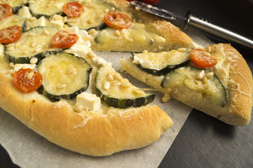 vegetable pizza, zucchini, cherry. on paper parchment.