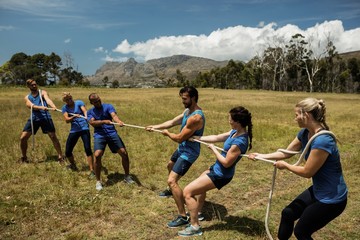 People playing tug of war during obstacle training course