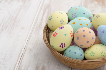 Hand-Painted Easter Eggs in Wicker Bowl Copy Space