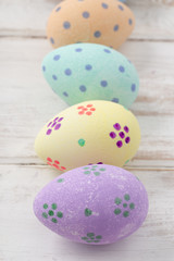 Close Up of Painted Eggs in a Column on Wooden Surface