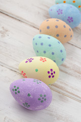 Hand-Painted Pastel Easter Eggs on Wooden Surface