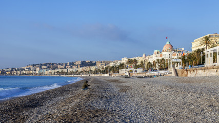 sun lights Promenade des Anglais - the main embankment of the city, one of the most beautiful in the world, and the city pebble beach © Elena Belyaeva