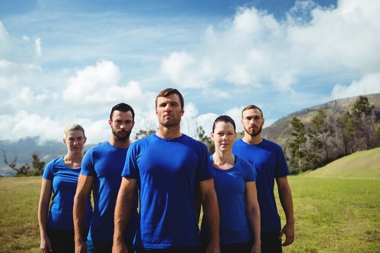 Group of fit people posing together in boot camp