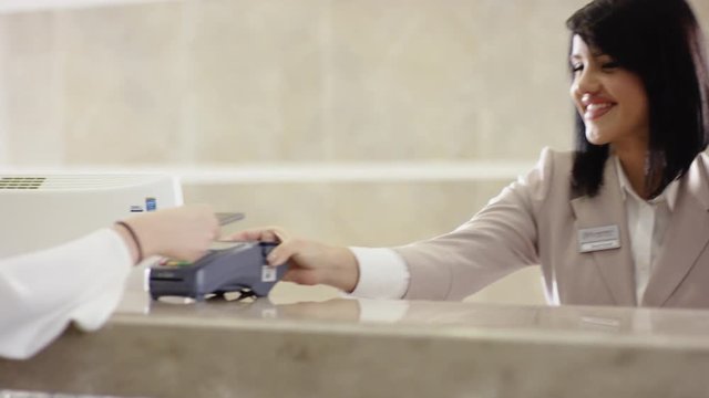charming girl Using Credit Card Terminal and looking at camera