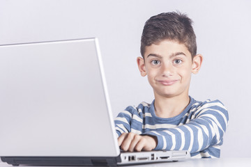 Smiling young boy using a laptop computer (e learning concept)