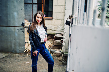 Portrait of stylish young girl wear on leather jacket and ripped jeans at streets of city. Street fashion model style.