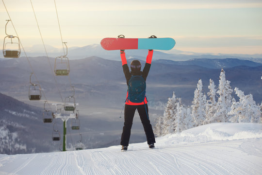 The girl with a snowboard on the  ski resort
