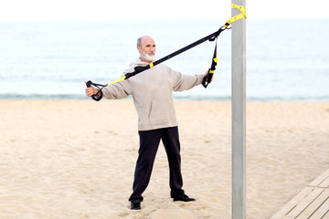 Senior macht cross-fit training am Strand 