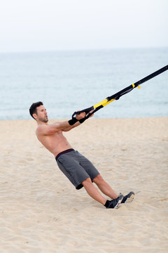 Athletischer Mann macht workout am Strand