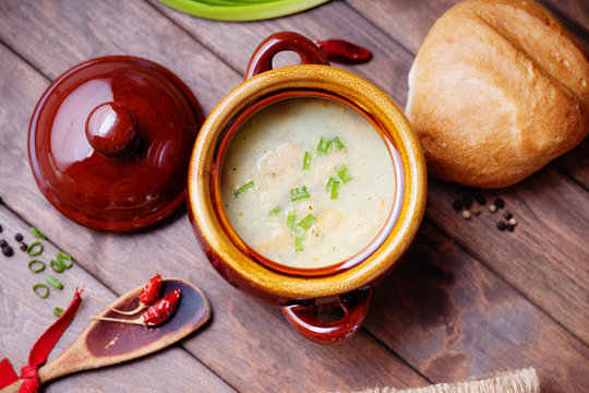Cheese soup, bread bun and wooden spoon 