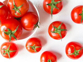 Fresh tomato juicy on a branch close-up on a light background horizontal view top view