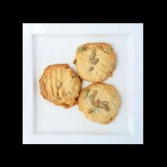cookies with nuts in white plate on black background