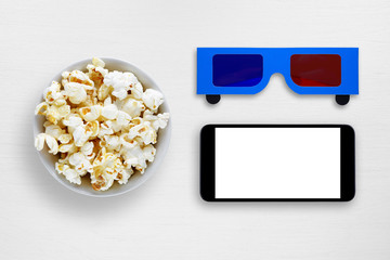 Popcorn, smartphone and 3d anaglyph glasses on white table
