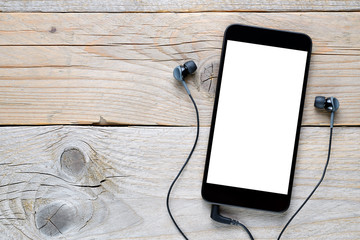 Smartphone and earphones on wooden background