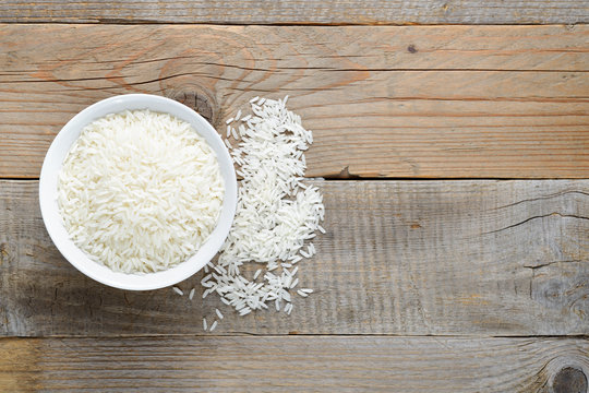 Jasmine Rice In Bowl On Wooden Table Top View