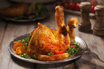 Baked chicken leg, served with roasted potatoes and vegetables.