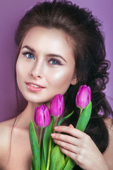 Portrait of romantic young woman with pink flower looking at camera .  Spring fashion photo. Inspiration of spring and summer. Perfume, cosmetics concept.