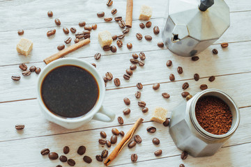 Coffee beans and cup of coffee on table on background