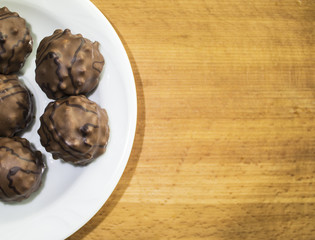 Candy in a plate on a wooden background