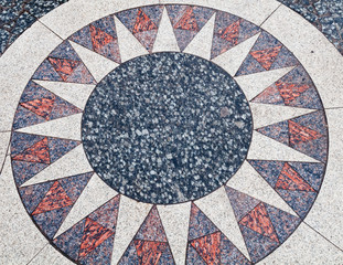 Concentric pattern in form of sun from granite plates of different color.