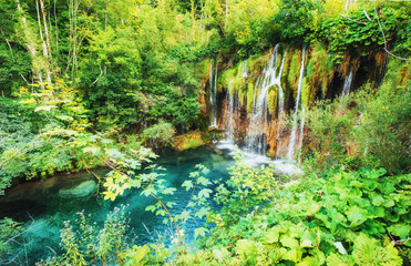 Fototapeta na wymiar Waterfalls in national park falling into turquoise lake. Plitvice, Croatia