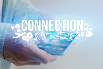 Concept of man holding a futuristic interface with connection title and multimedia icons flying all around - Internet concept
