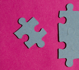 Jigsaw puzzle pieces on bright pink background