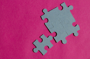 Jigsaw puzzle pieces on bright pink background