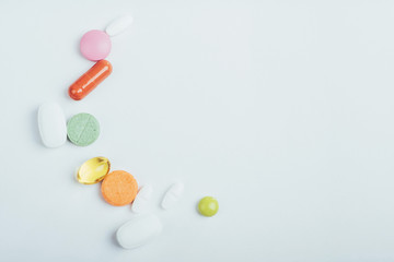 Medical colorful pills, capsules or supplements for the treatment and health care on a light background