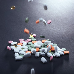 Medical colorful pills, capsules or supplements for the treatment and health care on a black background