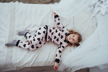 Child in soft warm pajama playing in bed