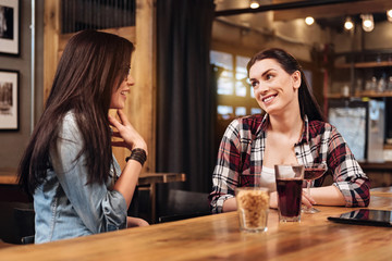 Delighted brunette holding glass with cocktail