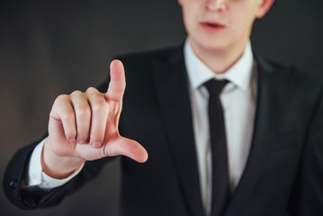 Businessman hand pointing on empty space on black background