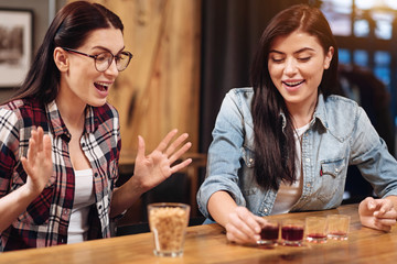Happy female persons looking at glasses