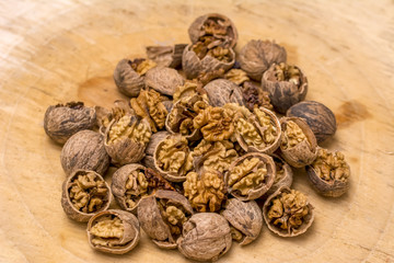 Walnut kernels and whole walnuts wood background