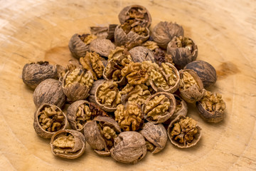 Walnut kernels and whole walnuts wood background