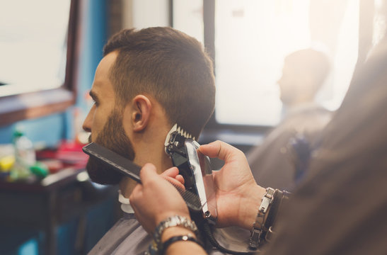 Man getting haircut by hairstylist at barbershop