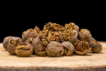 Walnut kernels and whole walnuts wood background