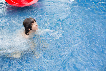 Sweet child, boy, playing in water world playground, enjoying attractions