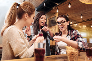 Joyful girls doing tricks with glasses