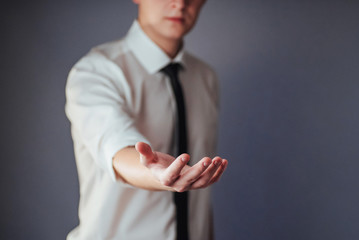 Young businessman showing empty hands, ready to fill with your design