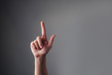 Close up view of the human hand, touching his index finger on a gray background. Valet touchscreen....