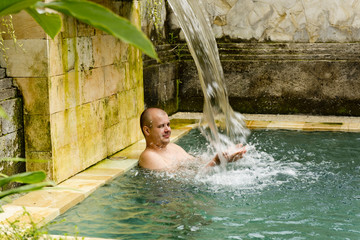 Young man in the pool in a luxury villa.