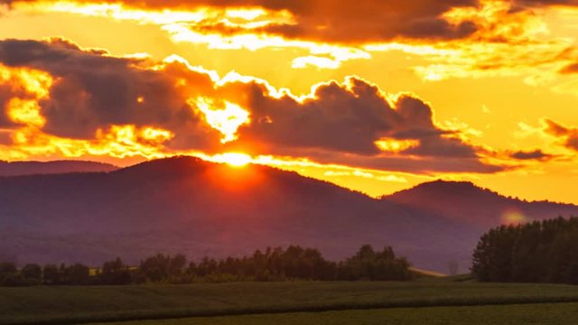Biei Hill View The Patchwork Road sunset time lapse - Time lapse of the sun setting behind the field hill in biei hokkaido