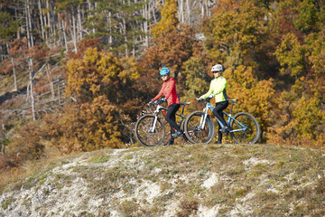 Fototapeta premium Mountain bikers training at the hillside. A group of female mountain bikers making their way across a rocky hillside.