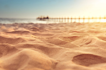 Close up sand with blurred sea sky and sunlight background, summer day, copy space or for product.