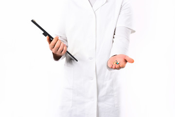 Male hands of doctor holding clipboard and pills