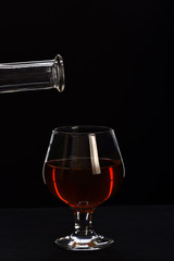 glass, carafe with cognac or whiskey isolated on black background