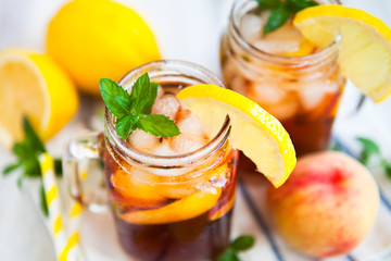Homemade lemonade with ripe  peaches and fresh mint. Fresh peach ice tea on white wood table. Copy space background.