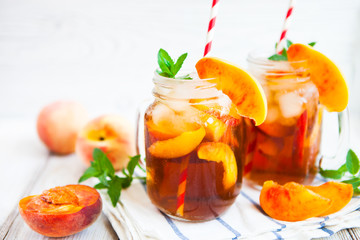 Homemade lemonade with ripe  peaches and fresh mint. Fresh peach ice tea on white wood table. Copy space background. - 141483748